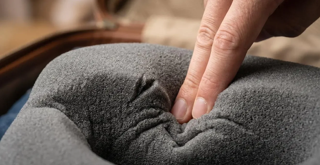 Main pressant un coussin de voyage en mousse à mémoire de forme pour tester sa densité